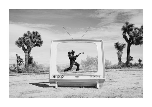 Cowboy inside a mid-century modern TV in the desert with a vintage "BANG" sign coming out the gun.